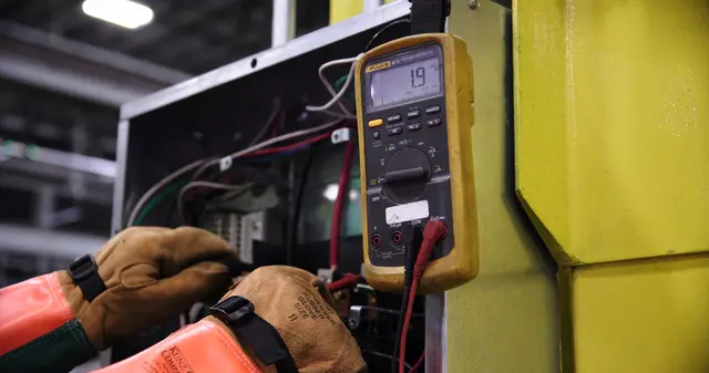 Técnico a verificar uma instalação elétrica com multímetro