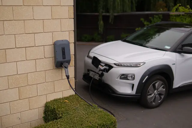 Wallbox instalada na parede de uma moradia com carro elétrico a carregar