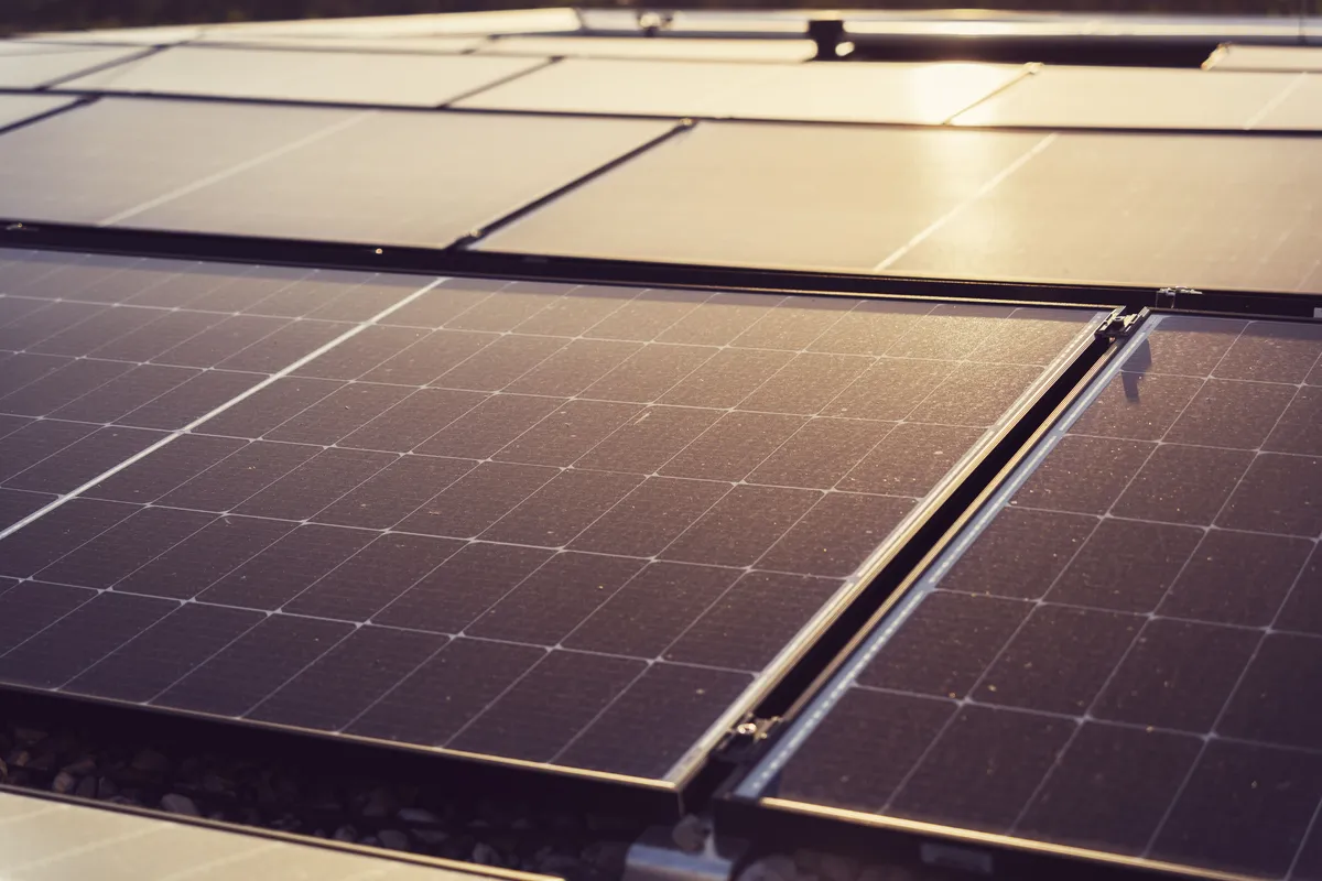 Painéis solares num telhado ao pôr do sol